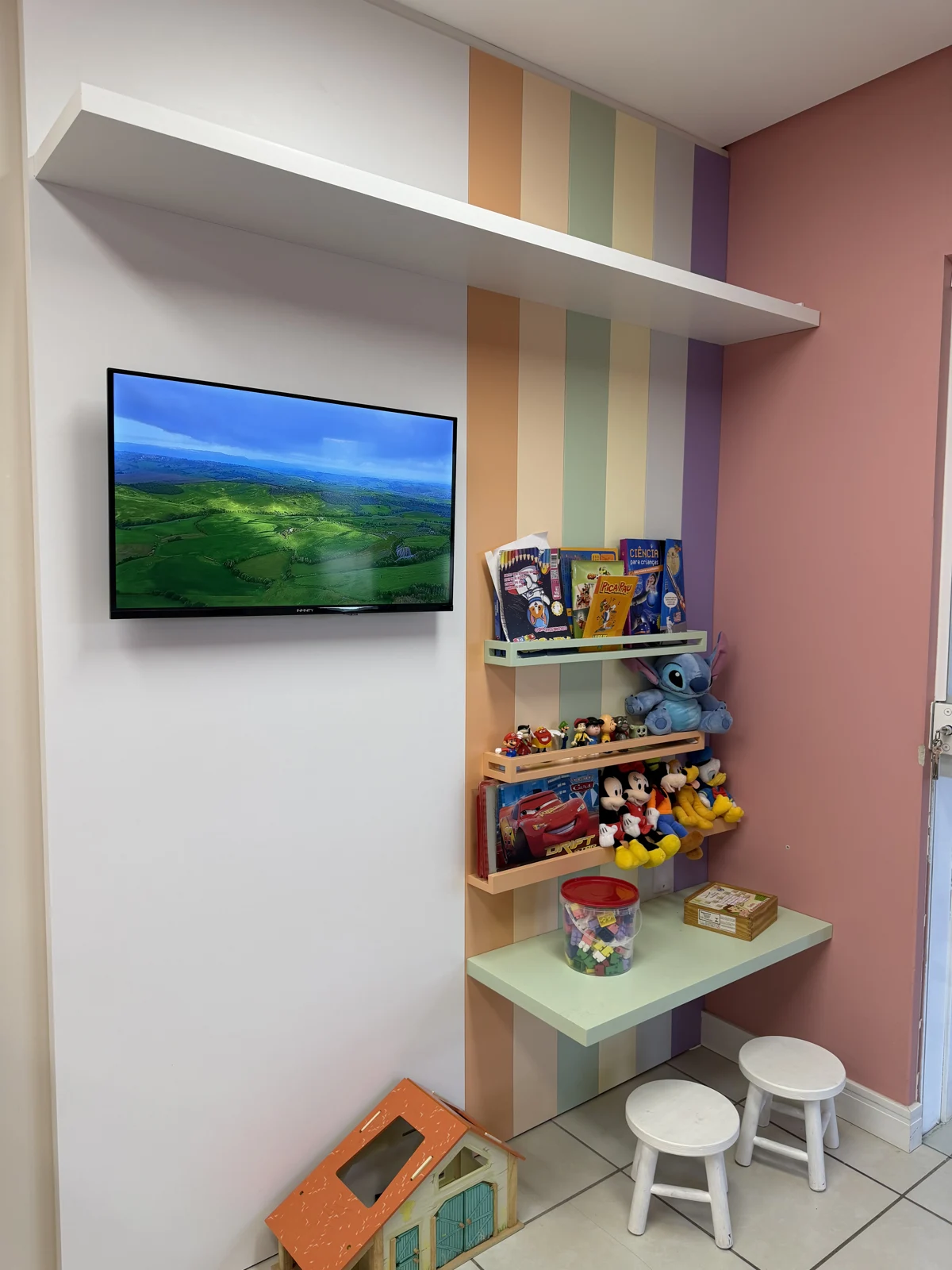Espaço kids com livros, brinquedos e televisão